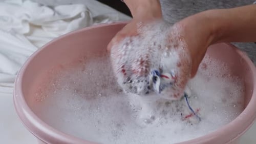 Washing Wet Checkered Towel in Basin with Froth and Washing Powder Closeup Using Detergent for