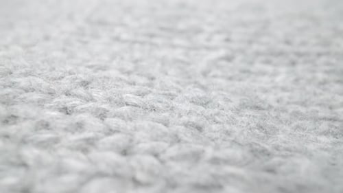 Extreme detail view of sheep wool cloth texture flowing in macro dolly shot.