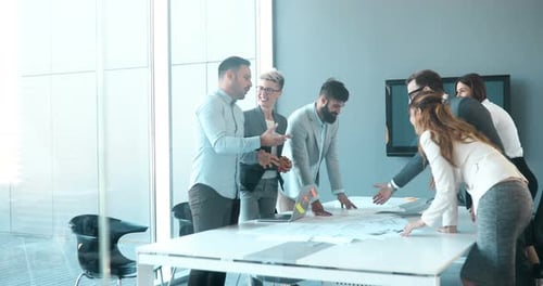 Business Team Collaborates Around Table in Modern Office