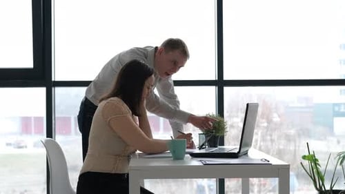 Man and Woman Discussing Project in the Office