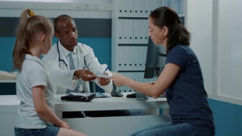 Doctor Consults with Patient and Mother in Office