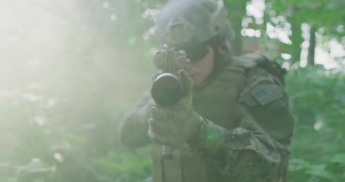 Silhouette of the Fully Equipped Soldier Moving Through Smokey Forest