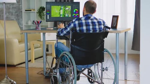 Man in Wheelchair Working at Computer at Home