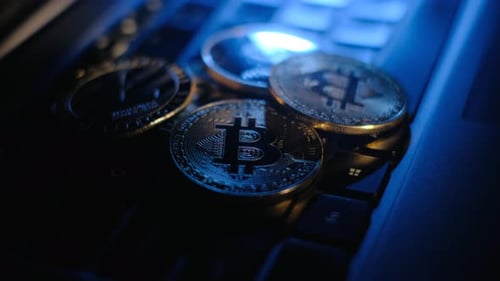 Cryptocurrency Coins on Laptop Keyboard in Blue Light