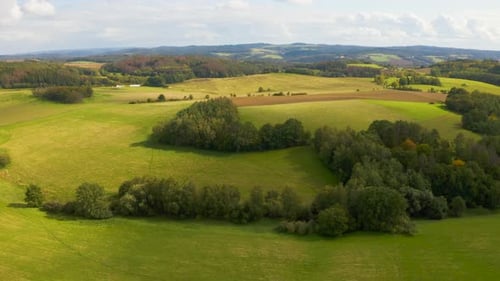 Aerial Drone Shot Hillsides with Fields and Patches of Woods in a Rural Area