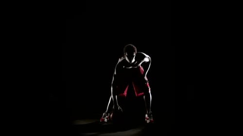 Mann spielt Basketball isoliert auf Schwarz
