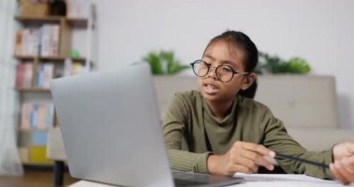 Girl with Glasses Doing Homework at Home