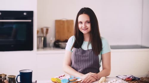 Woman Smiling in Kitchen with Freshly Baked Cookies
