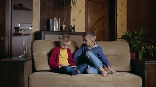 Children Playing Together on Smartphone on Couch