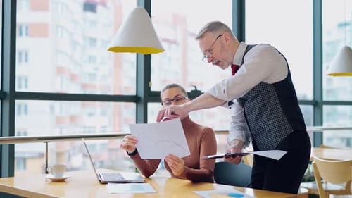 Professionals Reviewing Charts in Urban Office Workplace
