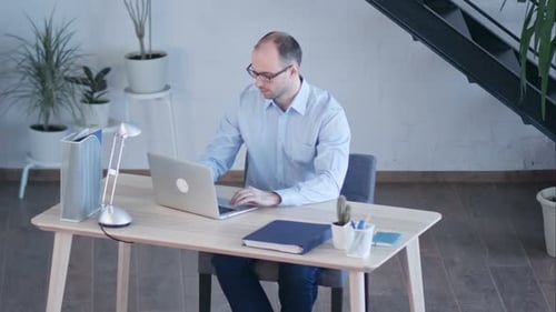 Handsome Businessman Working with Laptop in Office