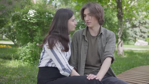 Young Couple Talking in a Park on Bench