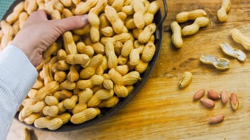 Close up of Peanuts on Table with Hand