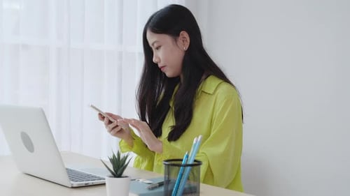 Young asian businesswoman working on laptop computer online on desk at home office.