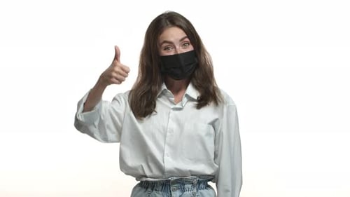 Young Adult Gives Thumbs Up Wearing Face Mask