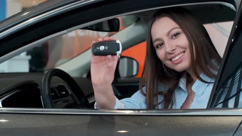 Young Woman Showing Key To New Car.