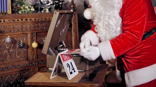 Santa Claus is turning a calendar page. Close up of Santa Claus with calendar.