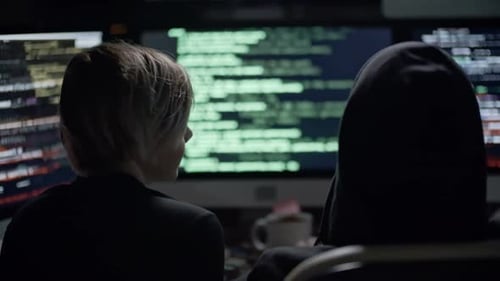 Young Adults Working at Computers Coding at Night