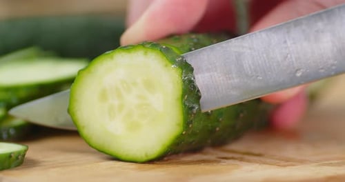 Male Hands Slicing Fresh Cucumber