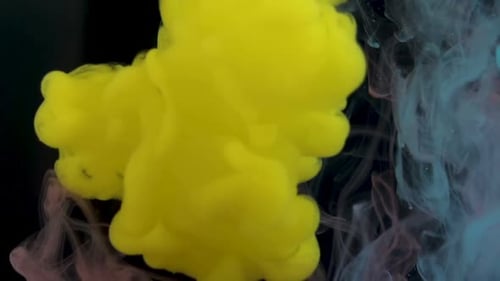 Lebendige gelbe Wolke in Wasser vor schwarzem Hintergrund und schafft eine abstrakte Szene