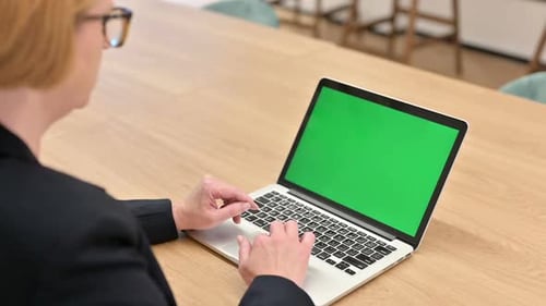 Typing on Laptop with Green Screen in Office