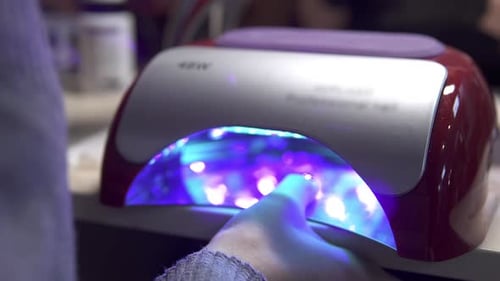 Hand Placing Fingers into Manicure Machine