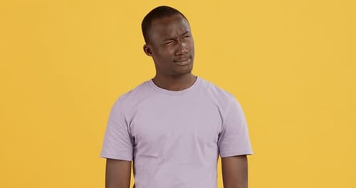 Portrait of African American Man Thinking Over Yellow Studio Background
