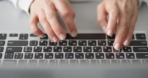 Female fingers are typing text on the laptop keyboard. Business woman works using a computer.