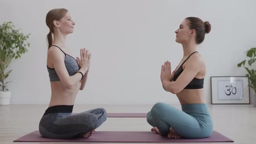 Two Women Meditating Face to Face Indoors