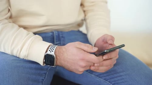 Person Using Smartphone While Wearing Smartwatch