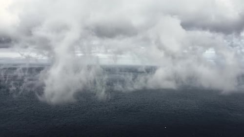 Foggy Skies Covering the View of Deep Ocean Waters and Mountains