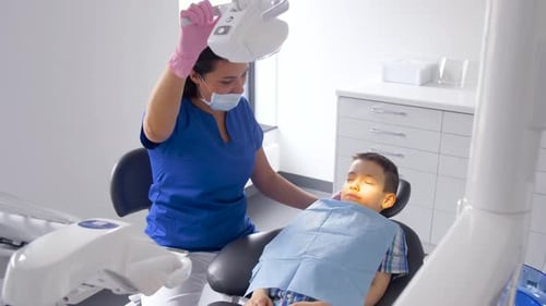 Female Dentist with Kid Patient at Dental Clinic