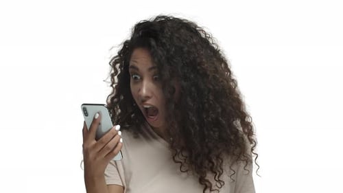 Closeup of Attractive Darkskinned Girl with Curly Dark Hair Looking at Smartphone Screen Receive