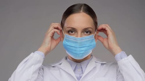 Woman Doctor Putting on Surgical Mask