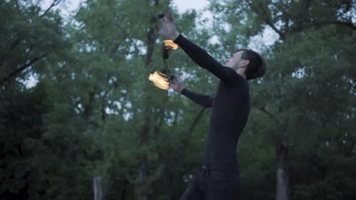 Man Performing Dramatic Fire Show in Forest at Night