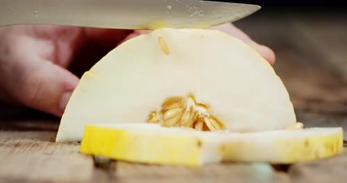 Die Hand eines Mannes, in eine frische Melone in Stücke geschnitten.