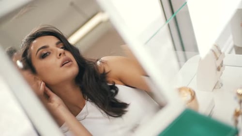 Woman Tries on Jewelry in a Boutique, Mid Shot