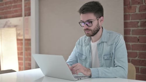 Man Working on Laptop at Desk Indoors