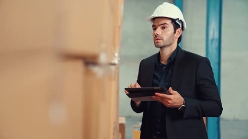 Factory Manager Using Tablet Computer in Warehouse or Factory