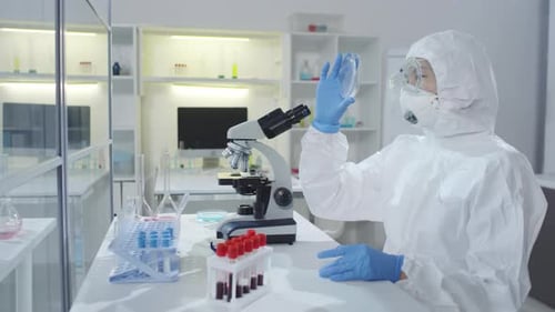 Medical Scientist Looking into Microscope