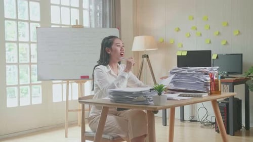 Woman Reviews Documents in a Bright Office