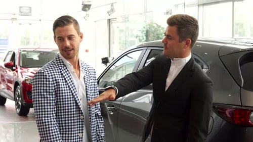 Man Buying Car in Auto Dealership Shakes Hands