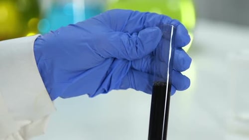 Research Lab Assistant Examining Sample of Raw Oil for Impurities and Sediments