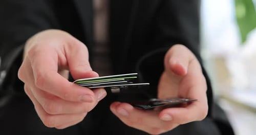 Person Stacks Credit Cards in Close Up Shot