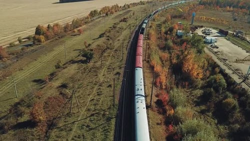 long freight train with building materials is moving by railway