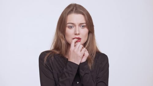 Worried Young Woman Biting Nails in Studio
