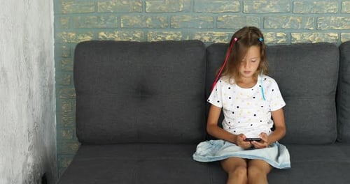 Girl Using Smartphone on Couch at Home