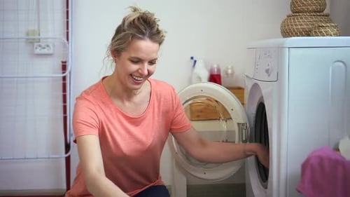 Woman Loading Washing Machine in Bright Laundry Room
