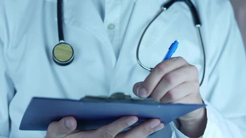 Close Up of Doctor Writing on Clipboard
