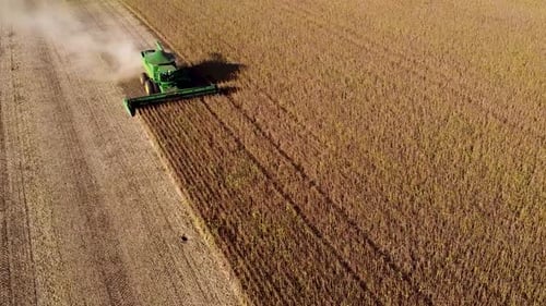 Green Combine Harvesting Crops in Field Aerial